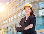 Portrait of Young Attractive Professional Female Contractor Wearing Hard Hat at Construction Site.