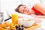 breakfast on a tray beside the bed sleeping girl