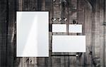 Blank stationery template for placing your design. Photo of blank stationery set on wood background. Blank letterhead, business cards, envelope, badge, and pencil. Mock up for branding identity. Top view.