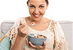 Beautiful happy woman at home eating a healthy bowl