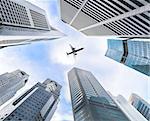 Business downtown skyscrapers and airplane in skies.