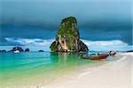 Wooden boats and a high cliff in the sea, Thailand, Phra Nang beach