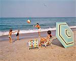 1970s FAMILY AT THE OCEAN BEACH BALL BATHING SUITS ALUMINUM CHAIRS UMBRELLA SAND SURF