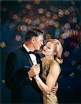 1960s ROMANTIC MATURE MIDDLE AGED COUPLE MAN WOMAN IN FORMAL ATTIRE EMBRACING DANCING