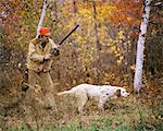 1960s 1970s MAN HUNTER WITH SHOTGUN IN AUTUMN LANDSCAPE PHEASANT HUNTING WITH ENGLISH SETTER GUN DOG ON POINT