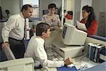 1990s ANXIOUS OFFICE WORKERS WAITING FOR INFORMATION FROM DESK TOP COMPUTER