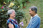 SENIOR ELDERLY ASIAN COUPLE LAUGHING IN GARDEN