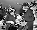 1960s TWO WOMEN WEARING HATS SHOPPING STANDING MEETING TALKING VISITING IN FRONT OF COSMETIC COUNTER OF DEPARTMENT STORE