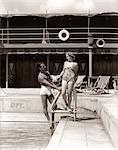 1930s MAN WOMAN COUPLE IN BATHING SUITS POOL SIDE VACATION HOTEL MIAMI BEACH FLORIDA USA