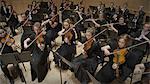 High angle view of student musicians playing violins in orchestra recital