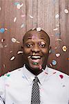 Businessman under falling confetti