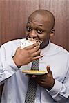 Businessman secretly eating cake