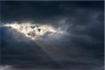 Sun breaking through dark storm clouds at Bamburgh in Northumberland, England, United Kingdom