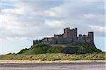 Bamburgh Castle and beach on a cloudy afternoon in Bamburgh in Northumberland, England, United Kingdom