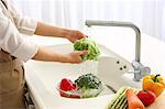 Japanese woman washing vegetables in the kitchen