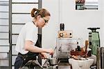 Female jeweller stirring saucepan in jewellery workshop