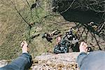 High angle perspective of boulderer above friends on boulder, Lombardy, Italy