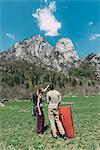 Young male and female boulderers looking up at mountain, Lombardy, Italy