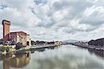 Old industrial tower on waterfront of Arno river, Pisa, Tuscany, Italy