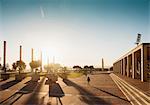 Female tourist at sunlit Olympic stadium, Barcelona, Spain