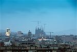 Elevated hazy cityscape view with La Sagrada Familia and construction cranes, Barcelona, Spain