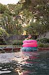 Young girl, standing in the middle of inflatable rings in outdoor swimming pool