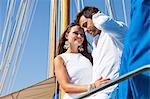 Couple relaxing on yacht, low angle view