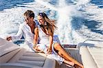 Couple relaxing on yacht, on water, looking at view