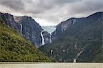 Waterfall flowing from glazier at edge of mountain rock face, Queulat National Park, Chile