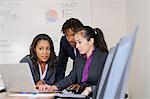 Businessman and businesswomen, in office, brainstorming, using laptop