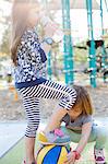 Little sister trying to retrieve basketball under girl's foot