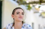 Woman sitting under trellis outdoors