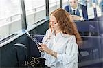 Young businesswoman looking at digital tablet on passenger ferry