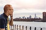 Businessman on waterfront making smartphone call, New York, USA