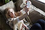 Woman taking selfie on sofa