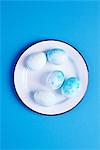 Overhead view of blue dyed easter eggs on blue background