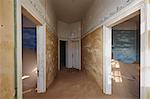 A view of rooms in a derelict building full of sand.