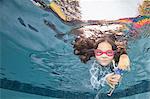 Underwater portrait of girl swimming holding doll