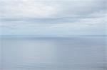 View from the land over the ocean, to the horizon where the sky meets the sea. Light clouds.