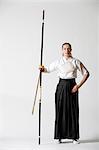 Caucasian woman practicing traditional Kyudo Japanese archery on white background