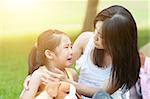 Portrait of Asian mother comforting her crying daughter in the park, Family outdoor lifestyle.