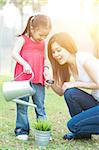 Asian mother and daughter are exploring nature and having fun. Family outdoor fun, morning with sun flare.