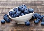 Fresh healthy organic blueberry in white bowl on wooden background