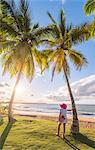 Playa Moron, Las Terrenas, Samana Peninsula, Dominican Republic. Woman relaxing on a palm-fringed meadow (MR).