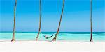 Juanillo Beach (playa Juanillo), Punta Cana, Dominican Republic. Woman relaxing on a hammock on a palm-fringed beach (MR).