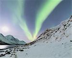 Panorama of the snowy Lyngseidet mountain illuminated by the Northern Lights and stars Lyngen Alps c Norway Europe