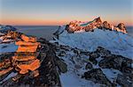 The rocky peaks of the Kongen Mountain and icy sea along the Mefjorden seen from peak Hesten at dawn Senja Tromsø Norway Europe