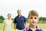 Boy with parents in background, portrait