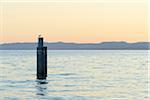 Gull on boat docking post at dusk on Lake Garda (Lago di Garda) in Garda in Veneto, Italy