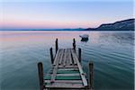 Old wooden jetty on the Lake Garda (Lago di Garda) at dawn in Garda in Veneto, Italy